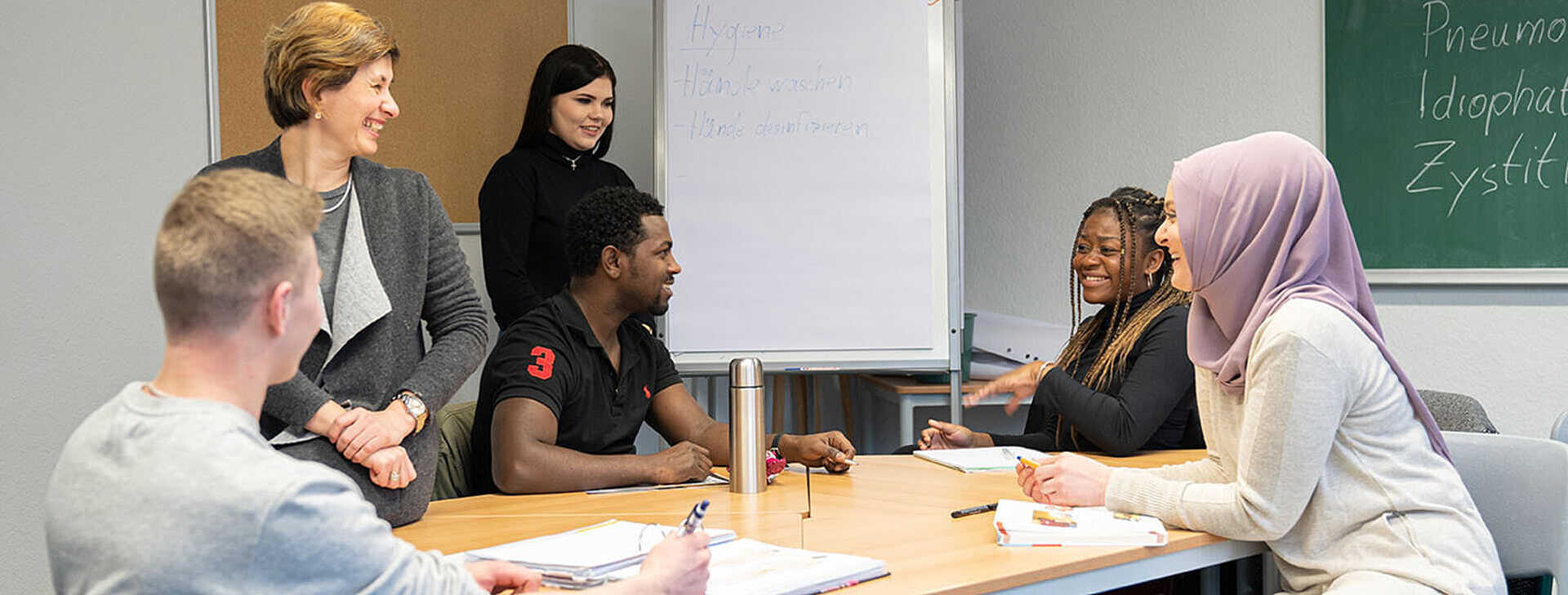 Gesprächssituation Besprechungsraum Fünf Personen sind um einen Besprechungstisch versammelt